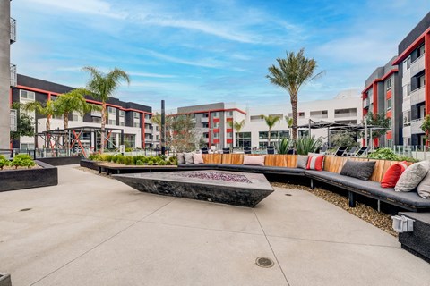 A modern courtyard with a bench and a fountain in the center.
